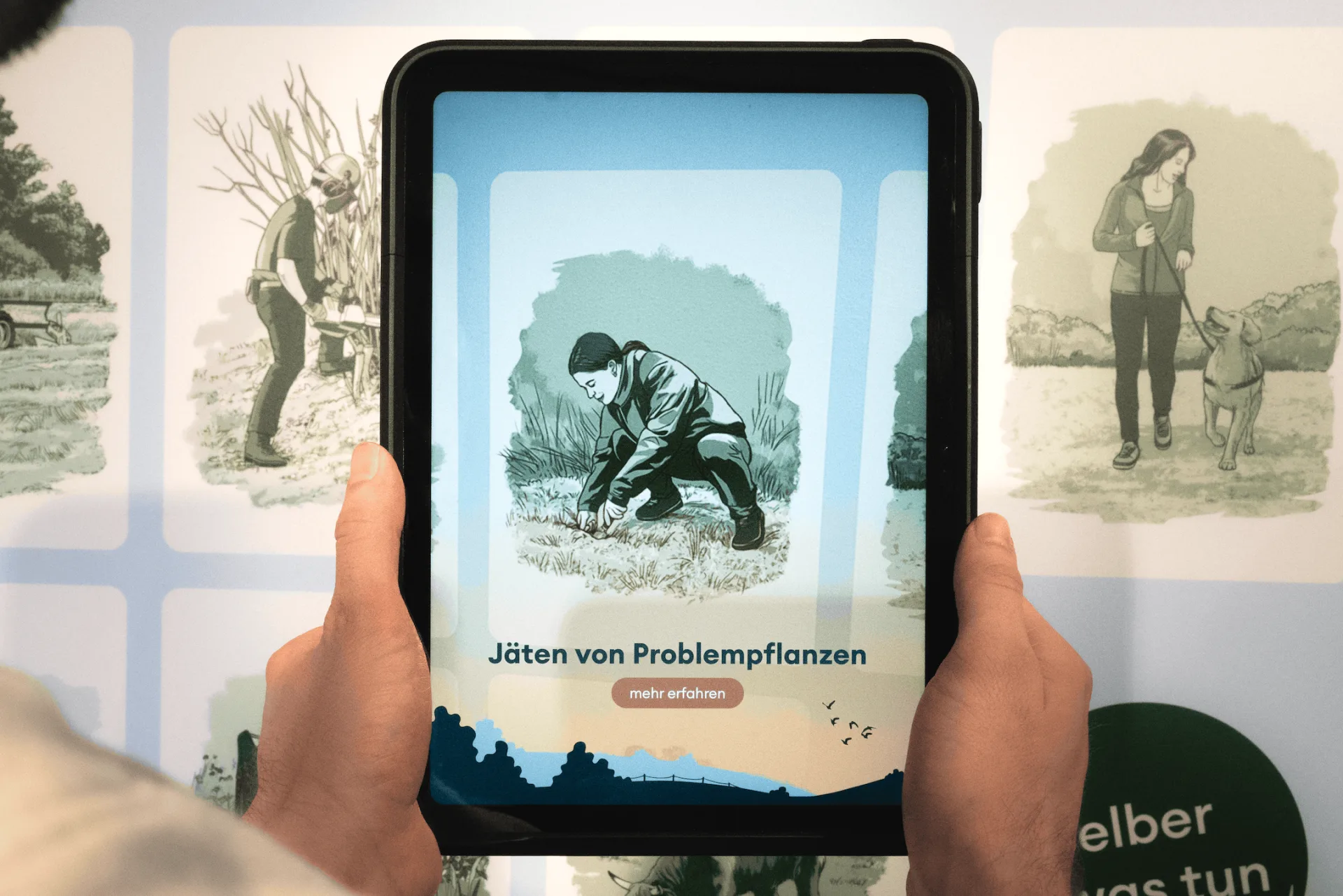 Eine Person hält ein Tablet und richtet die Kamera auf die Ausstellungsstation, um die dort platzierten Illustrationen zu scannen.