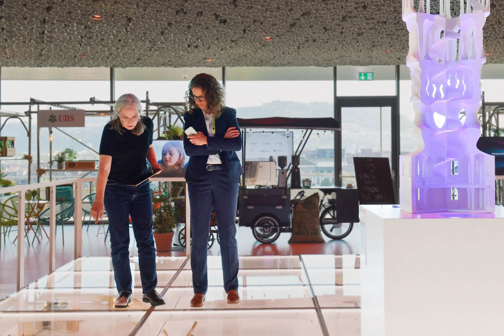 Simone zeigt einer Besucherin die Digital Platform.