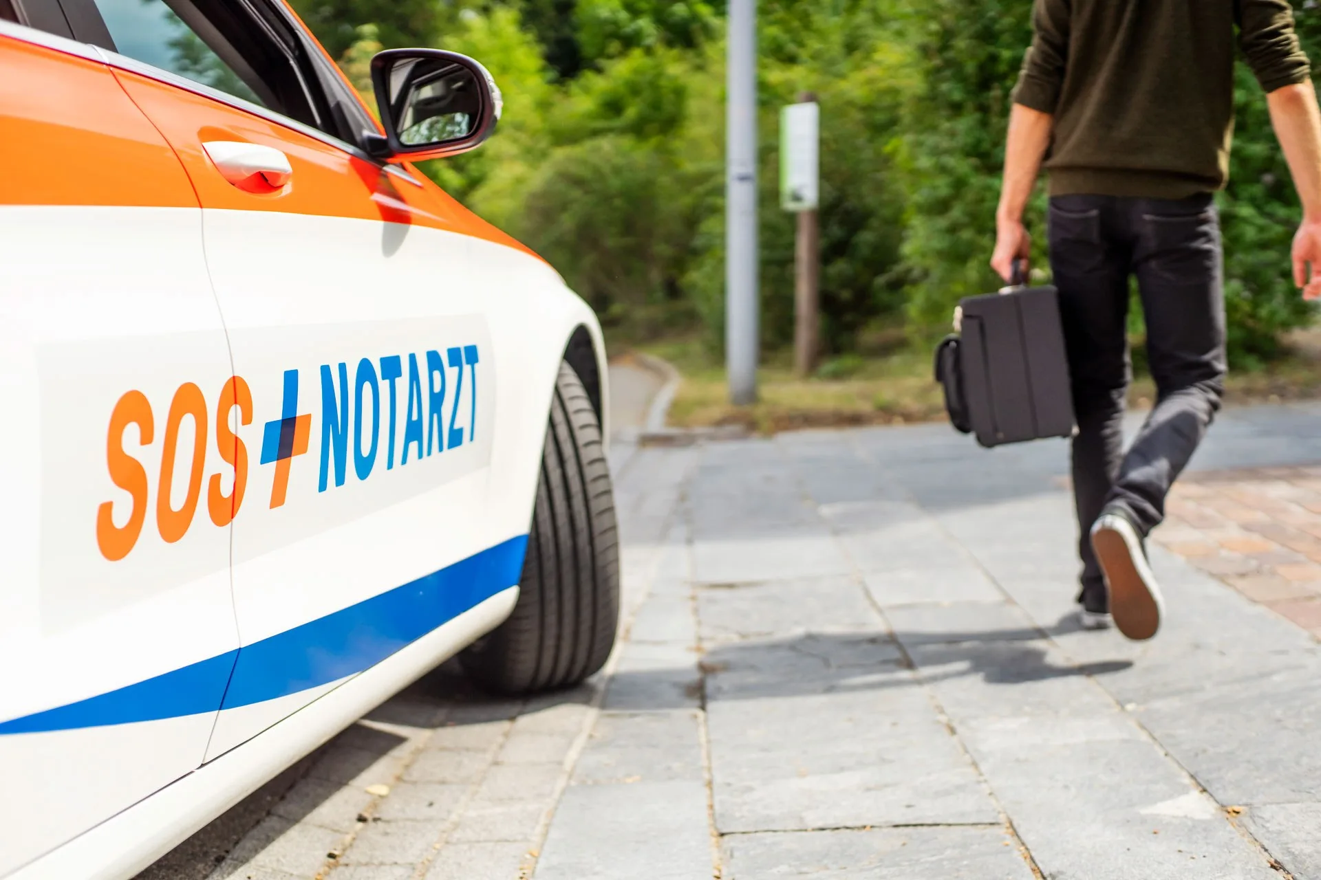 SOS Arzt auf Patientenvisite. Auto von SOS AERZTE im Einsatz.