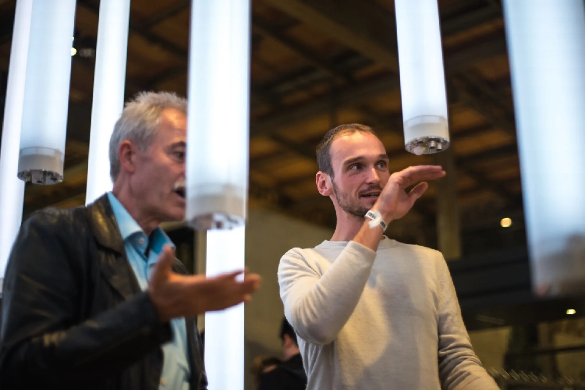 Zwei Männer aktivieren die Sensoren der Lichtröhren