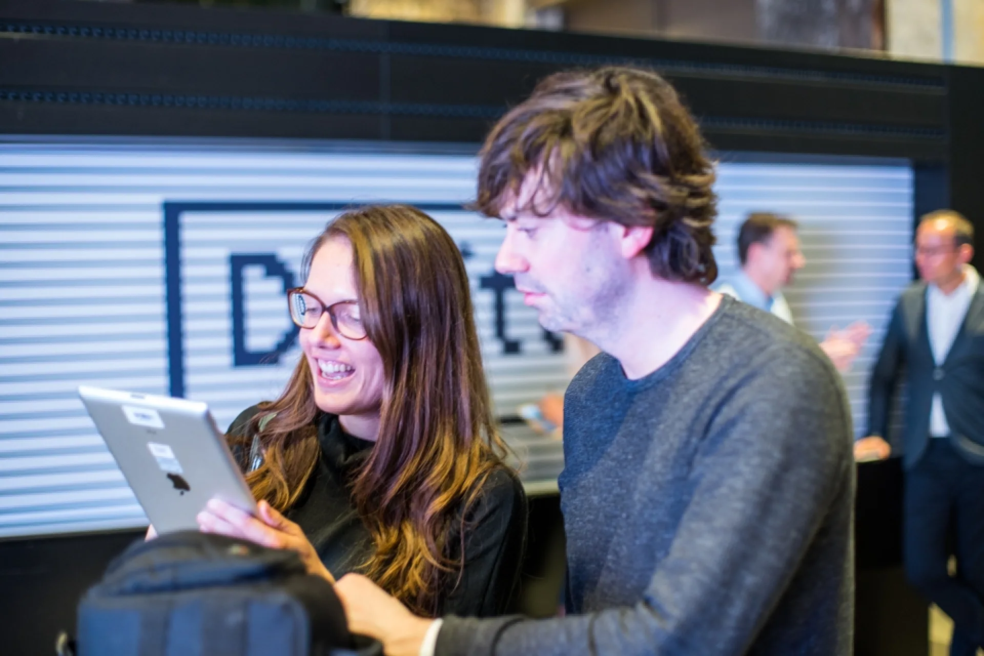 Zwei Besucher der Ausstellung bedienen ein iPad.