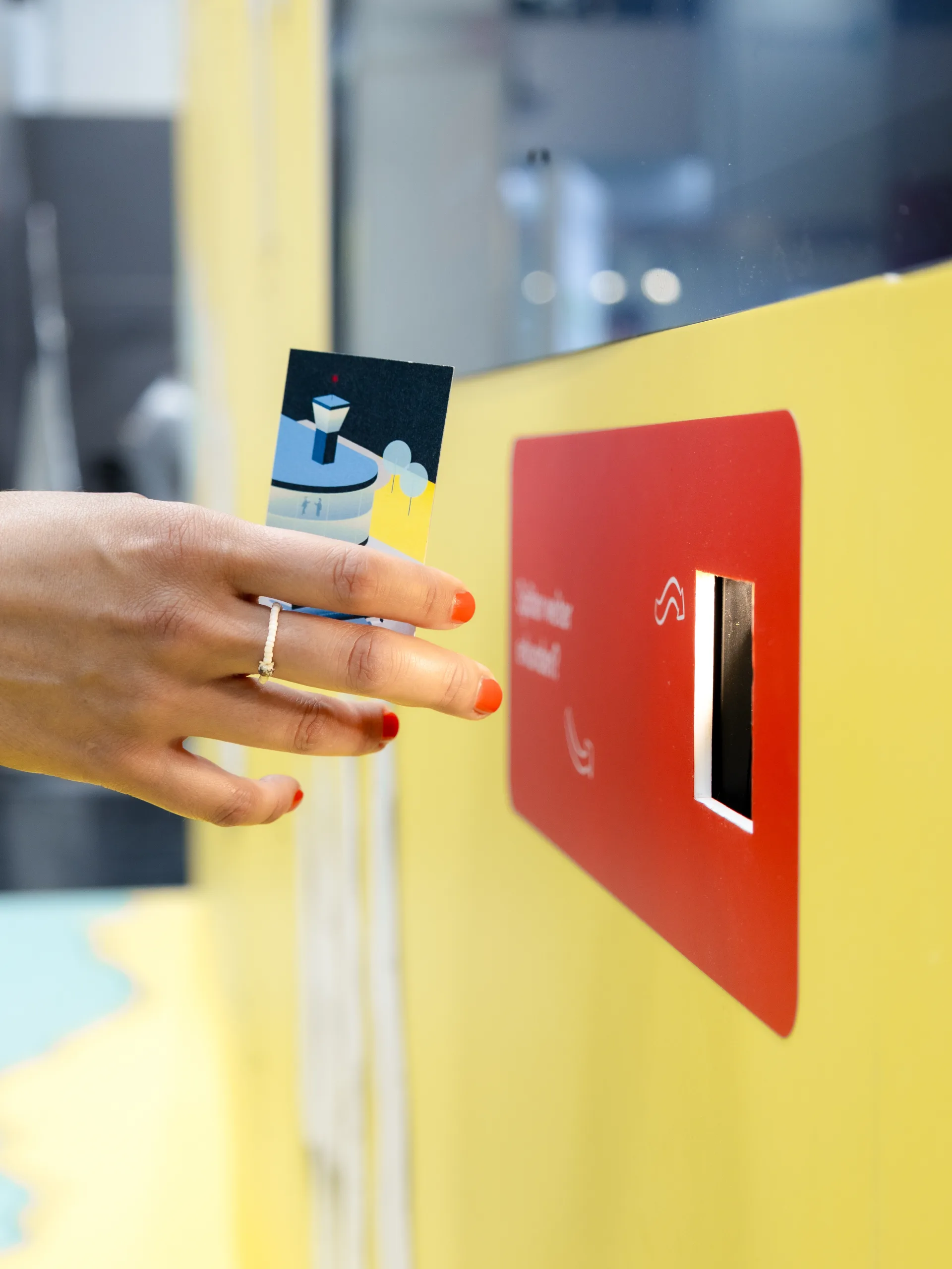 Nahhaufnahme einer Hand, welche eine Karte an einem QR-Code-Scanner scannt.